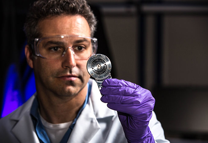 Scientist holding a metallic object