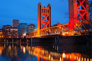 Picture of bridge with evening sky and skyscrapers in background